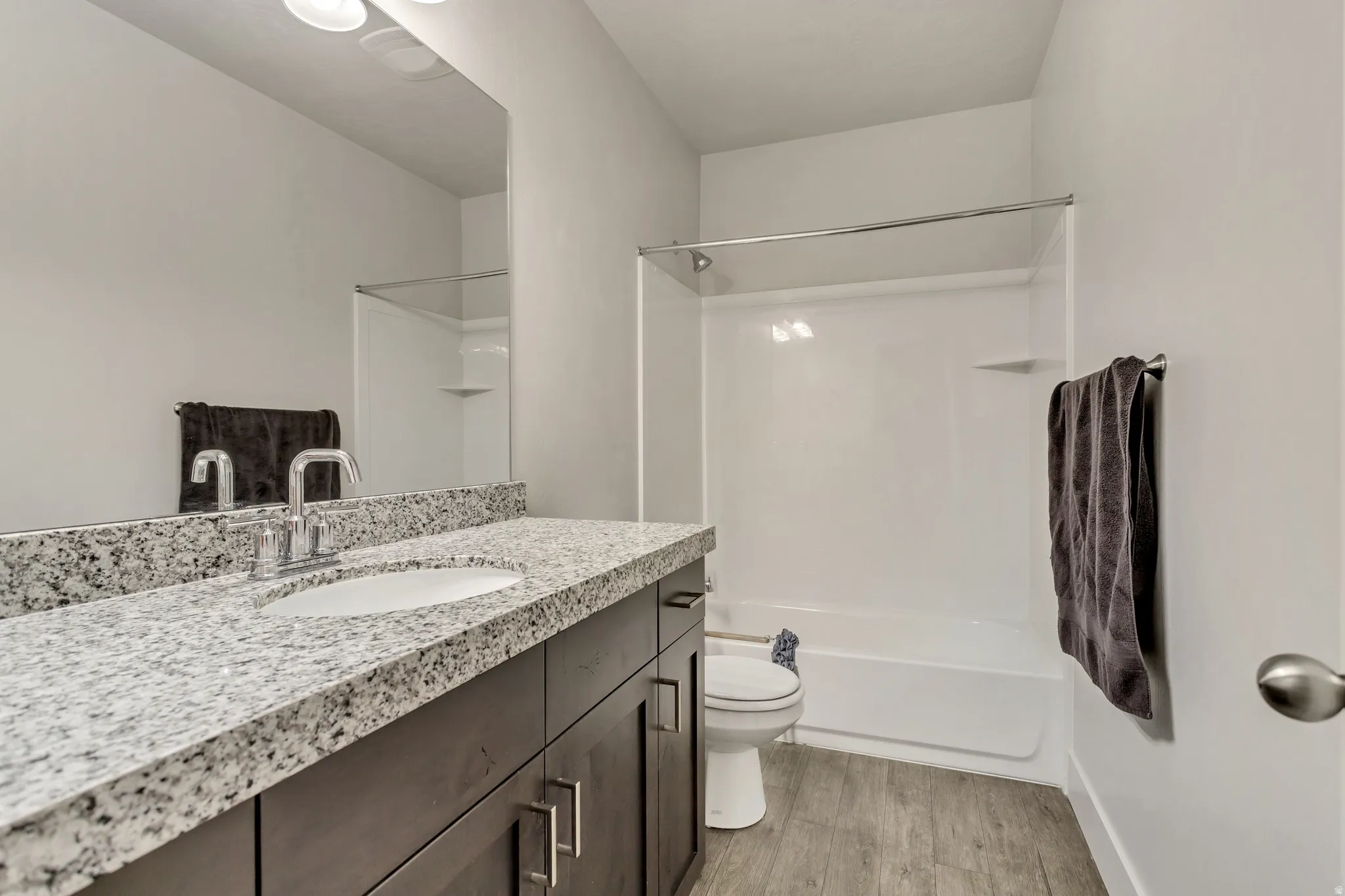 Vanity with speckled countertop, undermount sink, and chrome faucet