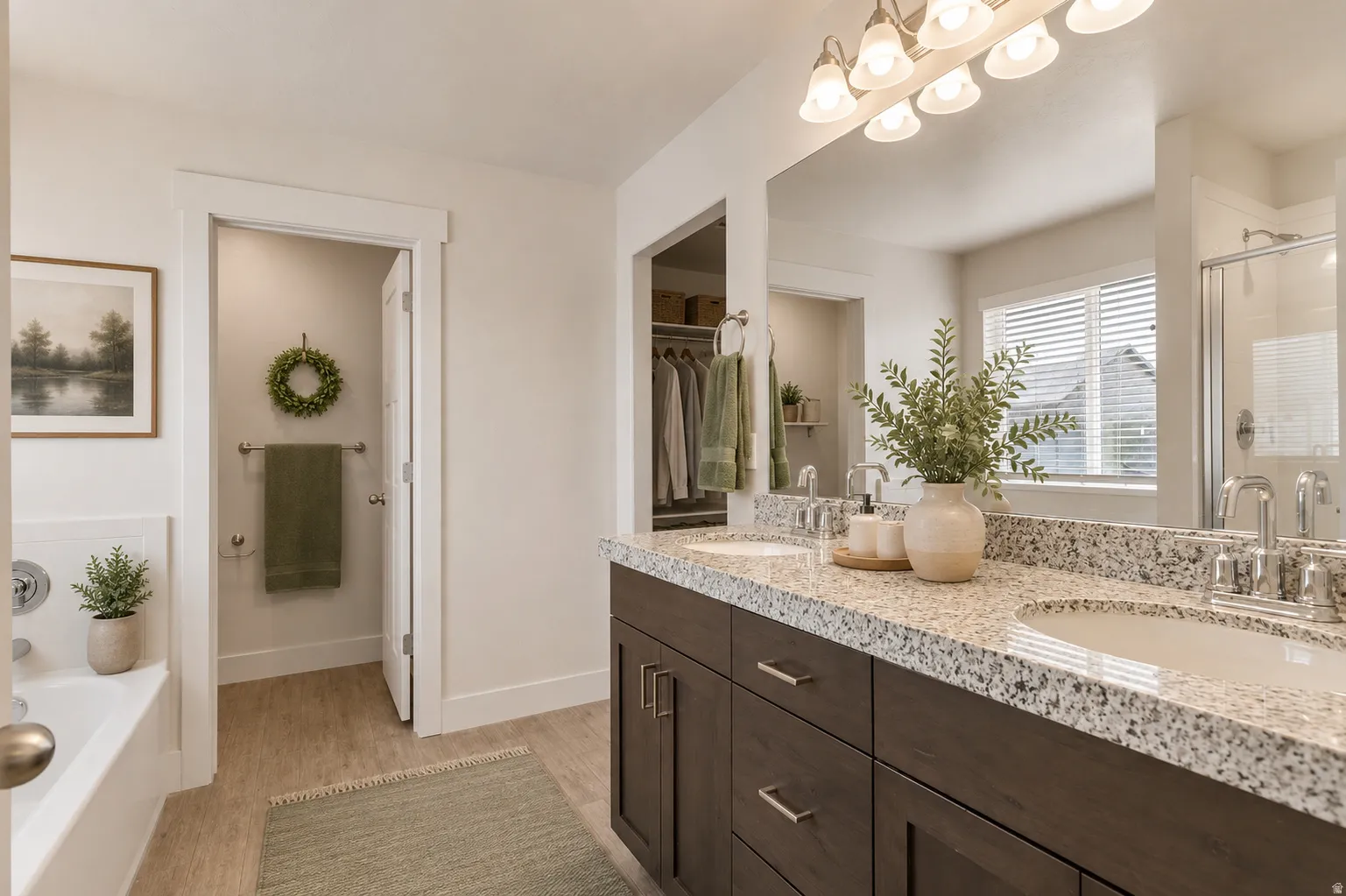 Dual vanity with granite-style countertop and undermount sinks, full-width mirror, and a built-in tub