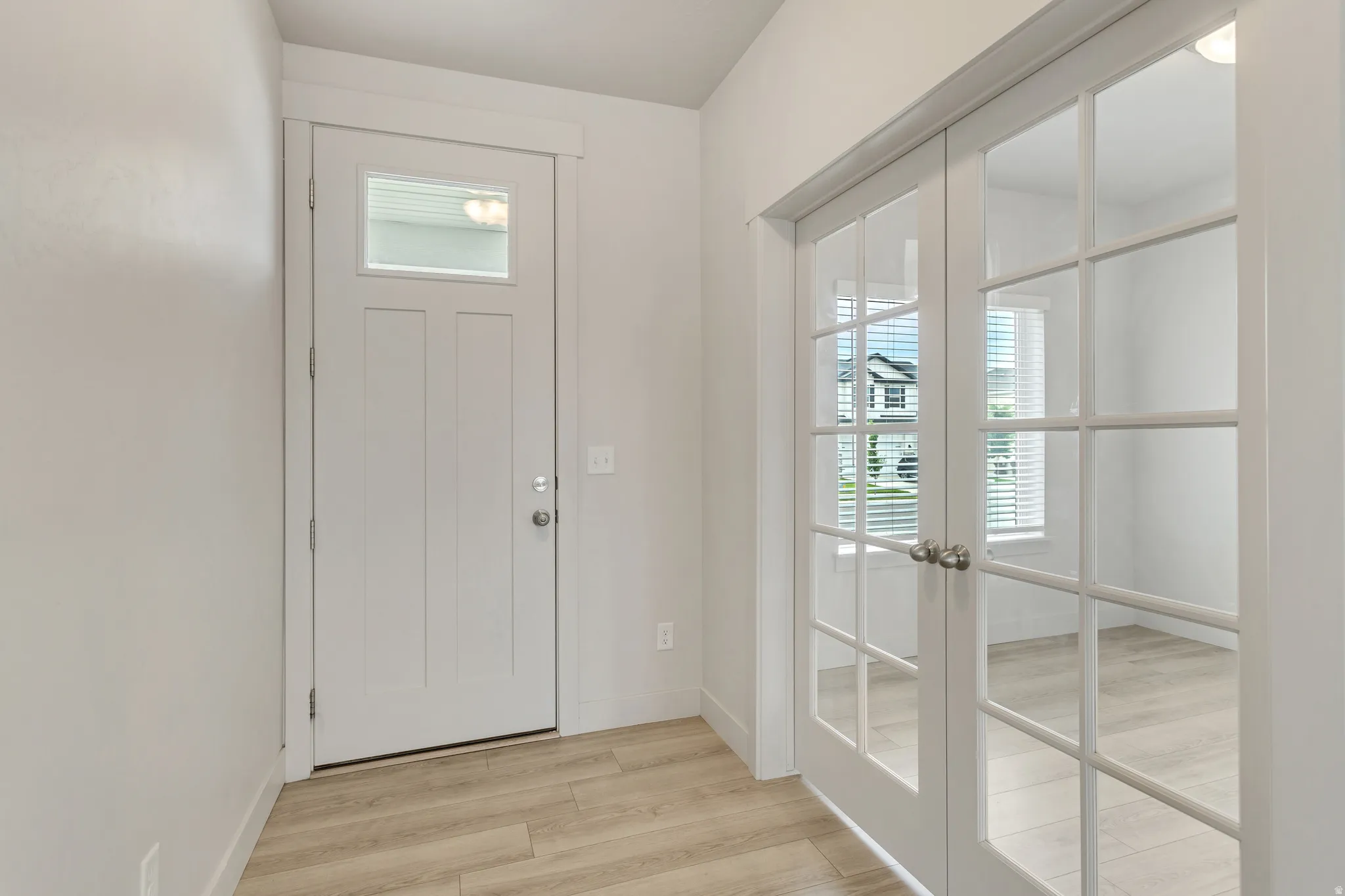White paneled entry door with transom window