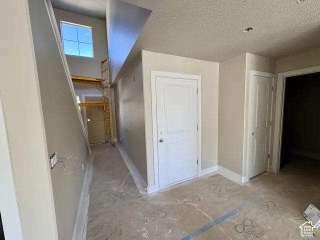 Two-story foyer with high ceilings, upper-level window, and recessed lighting