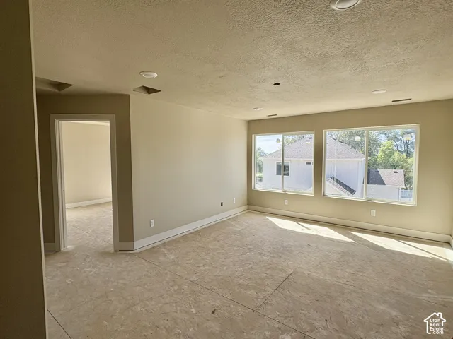 Spacious room featuring multiple windows, recessed ceiling lighting, and neutral wall tones