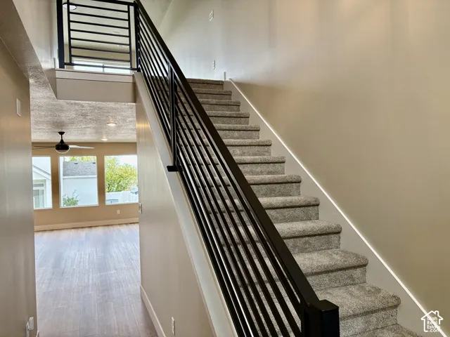 Staircase featuring carpeted treads and matte black metal railings