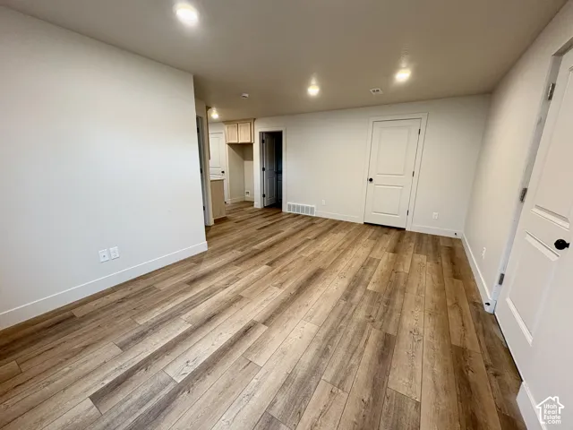 Wood-finish flooring throughout, recessed ceiling lighting, and solid-core paneled interior doors