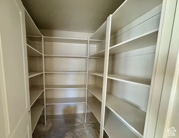 Built-in shelving with multiple levels, neutral wall paint, and a solid door