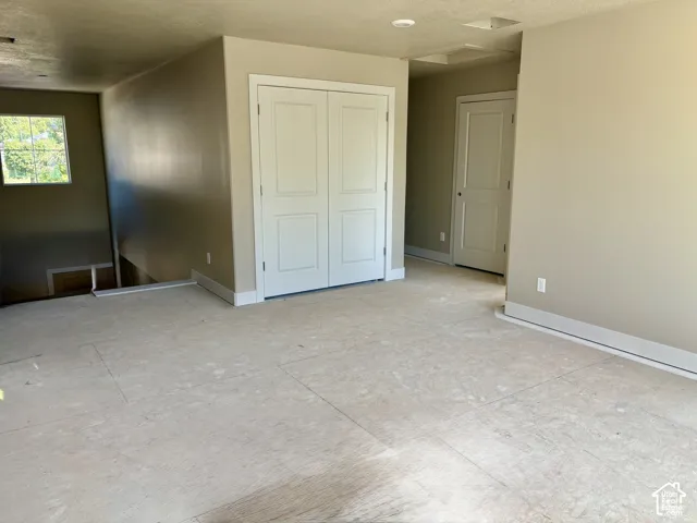 Recessed lighting, light neutral wall paint, white trim, paneled doors, and a window providing natural light