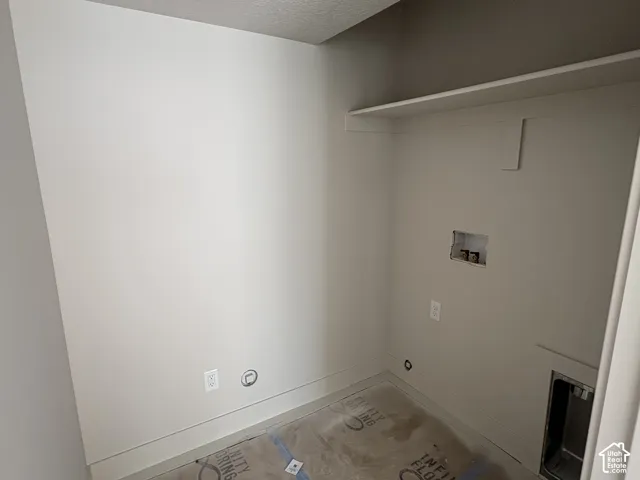 Utility area with a built-in shelf, neutral wall tones, and electrical outlets
