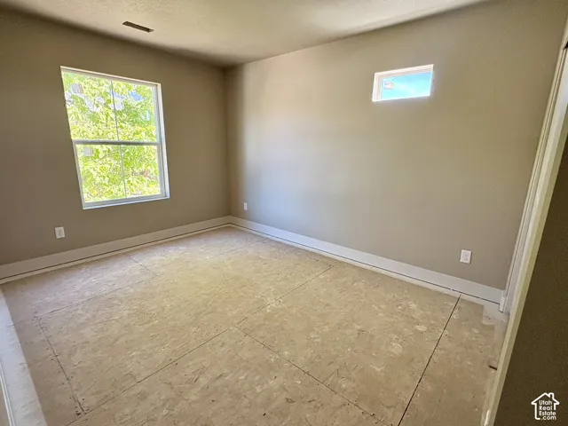 Neutral wall tones, dual window placement, and contemporary ceiling texture
