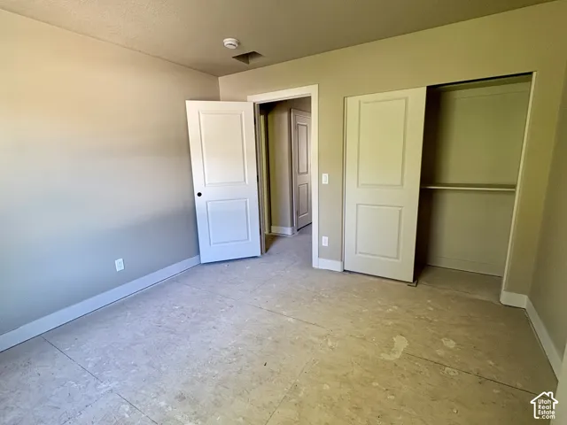 Neutral wall paint, white trim, and a built-in closet with a shelf
