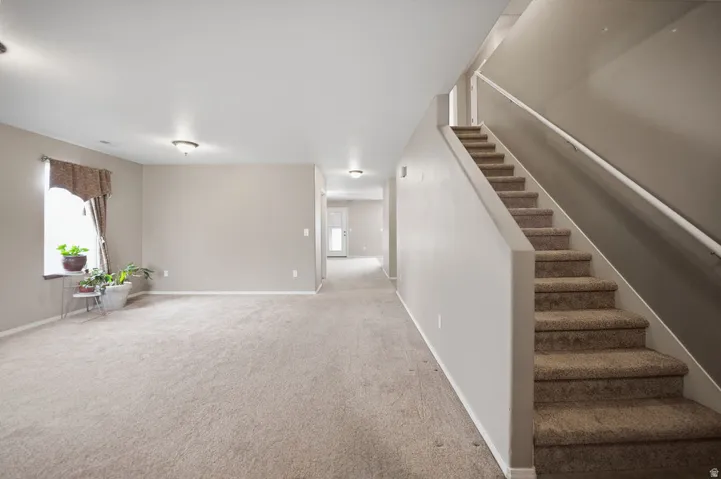 Spacious interior with neutral-toned walls, plush carpeting, and recessed lighting