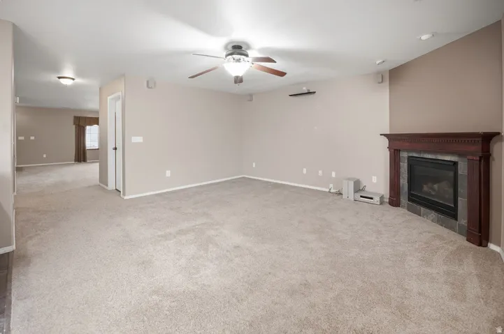 Living room 2 on main level. Corner fireplace with dark wood mantel and tile surround