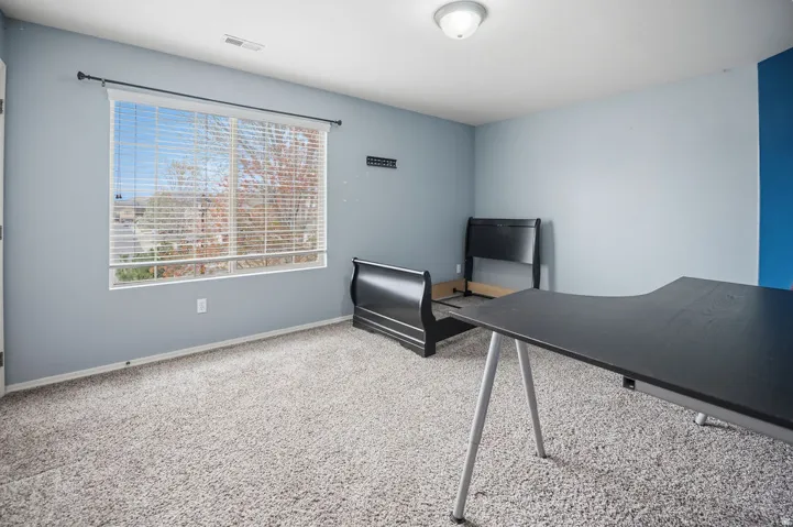 Light blue painted walls with an accent wall, carpeted flooring, and a large window with blinds