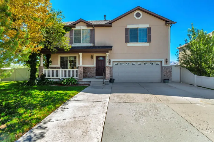 Two-story residence featuring a covered front porch, integrated two-car garage, and a concrete driveway