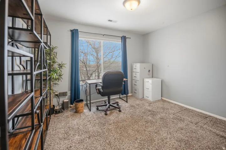 Carpeted room with a large window, neutral wall paint, and overhead flush-mount lighting
