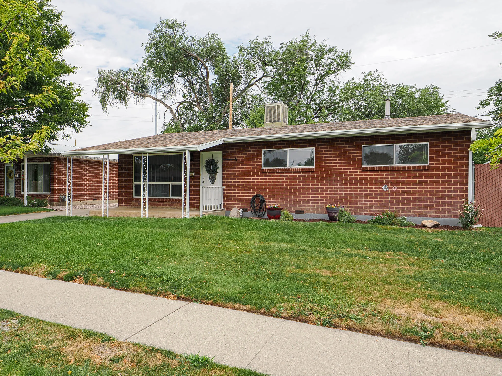 Brick exterior with a covered entryway and a concrete walkway