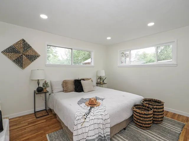 Recessed ceiling lighting, wood-finish flooring, and multiple windows with white trim