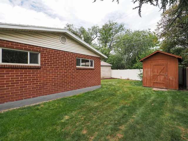 Brick exterior with vinyl siding, a gable roof, and a round gable vent