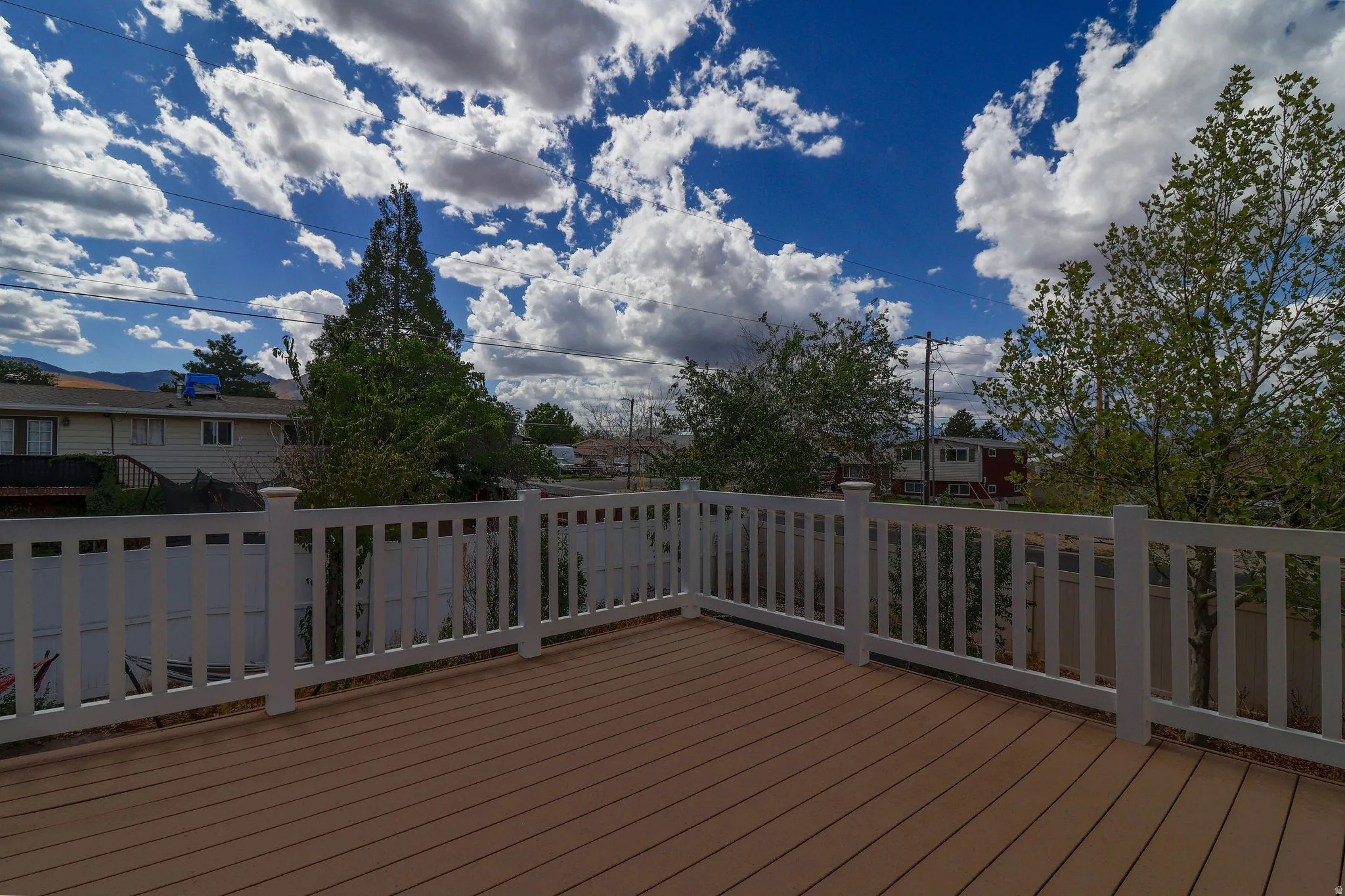 Expansive deck featuring wood-finish decking and white railings