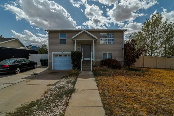Two-story exterior with light-colored siding, a covered front entry, and an attached single-car garage