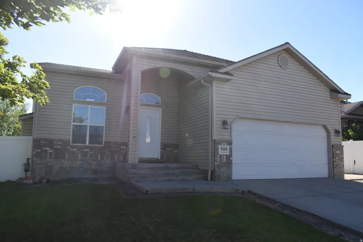 Siding exterior with a partial brick facade, arched entry, arched transom windows, and an attached two-car garage