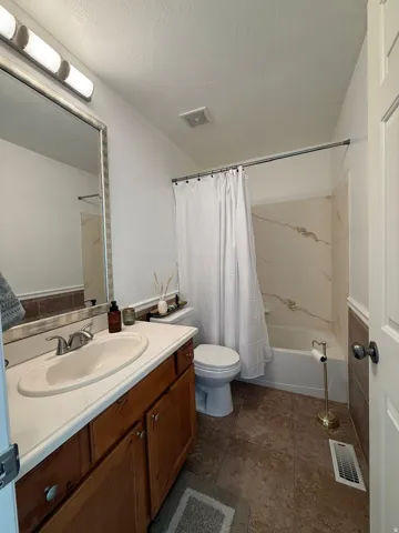 Wood-finish vanity with an integrated sink and chrome faucet