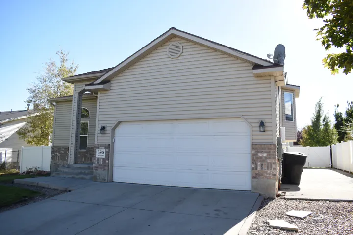 Bay window, attached garage, stone accents, vinyl siding, and concrete driveway