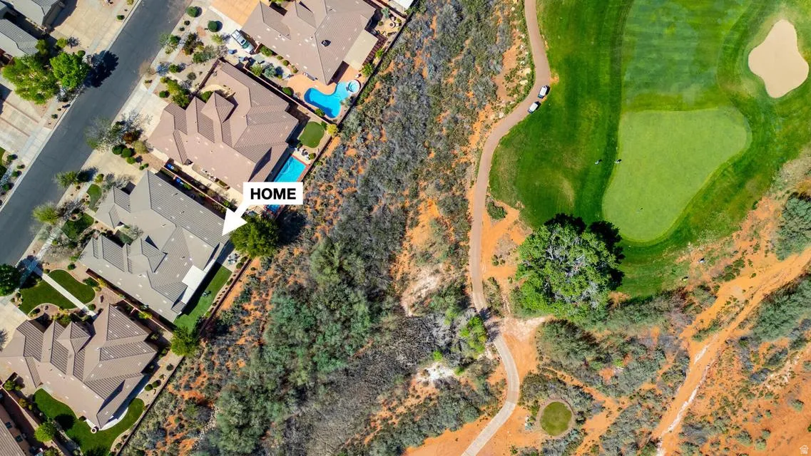 Property bordering a golf course with mature landscaping and a paved street