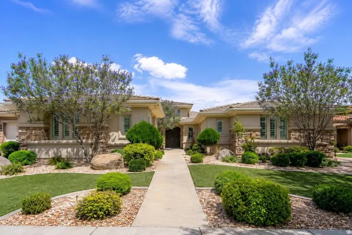 Symmetrical facade with stacked stone accents, decorative window shutters, and a central entry path