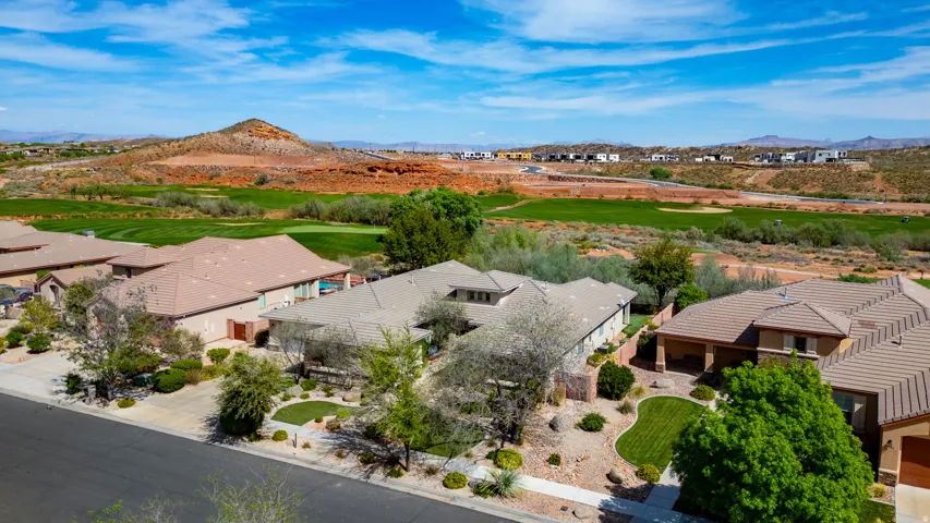 Residential neighborhood featuring tiled-roof properties with landscaped front yards and a manicured golf course