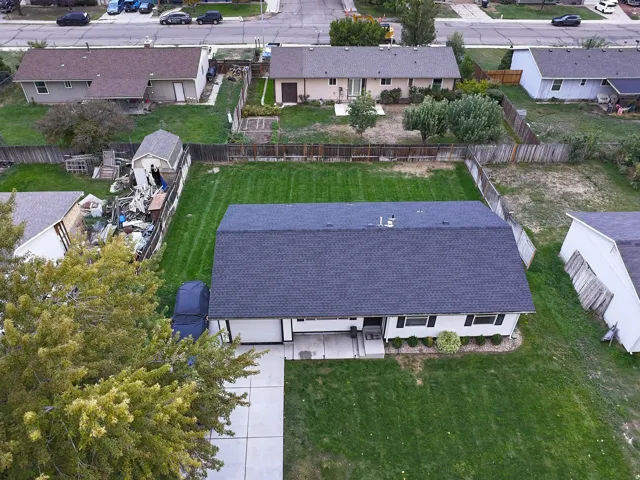 Single-story residence featuring an attached garage, a dark shingle roof, and a concrete driveway