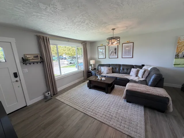 Wood-finish flooring throughout, bright window with white trim, and a modern ceiling light fixture