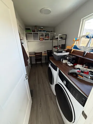 Wood-finish flooring with built-in shelving, a wood-finish countertop, and a window
