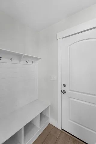 Thoughtfully designed mudroom providing a seamless transition from the garage to the main living area. A custom built-in storage bench with convenient cubbies keeps everyday items organized and accessible, while crisp white shiplap wall paneling creates a