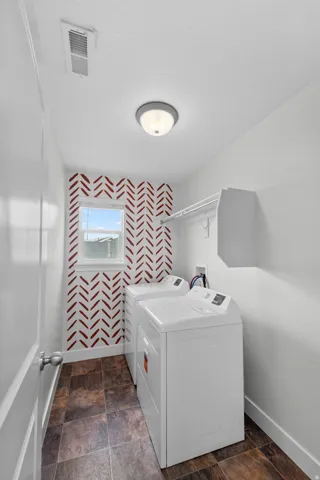 Conveniently located laundry room on the second floor, nestled near the master and primary bedrooms for ultimate accessibility. The thoughtfully designed space features a stylish patterned accent wall that adds visual interest and personality, while a win