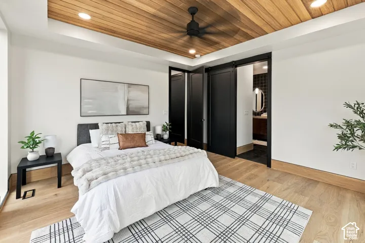 Master Bedroom with Brazilian hardwood, recessed lighting, matte black ceiling fan, wood-finish flooring, and black sliding barn door