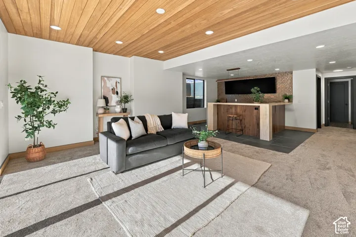 Interior space featuring a wood-plank ceiling, recessed lighting, and a built-in bar with a textured tile backsplash and wood-finish cabinetry