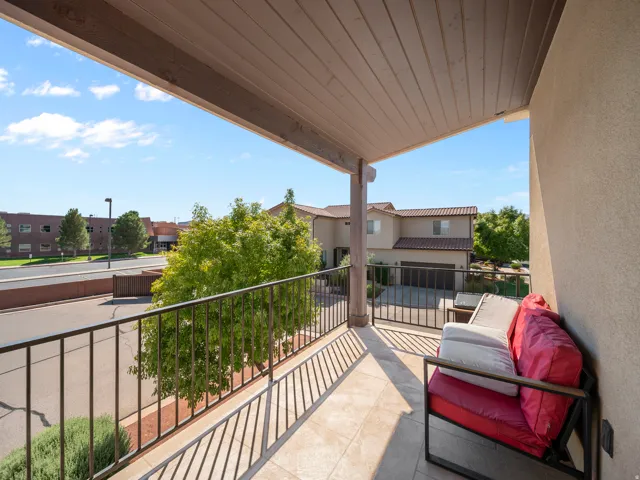 Covered balcony featuring tile flooring and a metal railing
