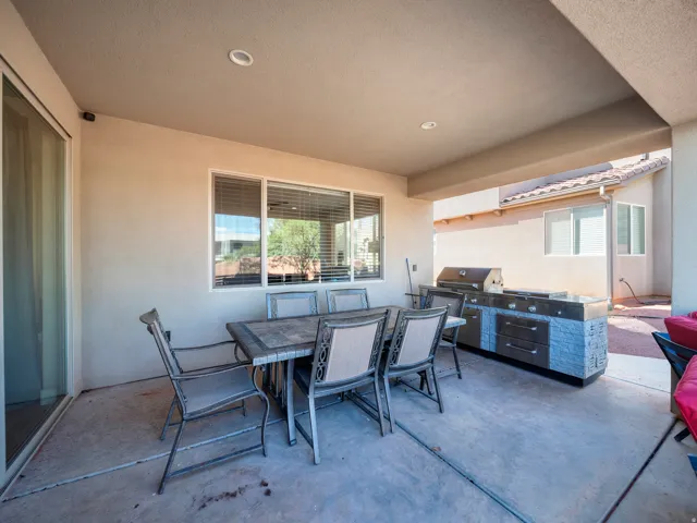 Covered patio featuring an outdoor kitchen with a built-in grill and integrated cabinetry