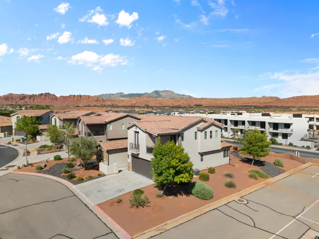 Modern stucco exterior with a tile roof, an integrated two-car garage, and desert-adapted landscaping