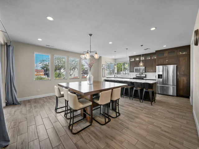 Open-concept living area with wood-finish flooring, recessed lighting, and multiple windows