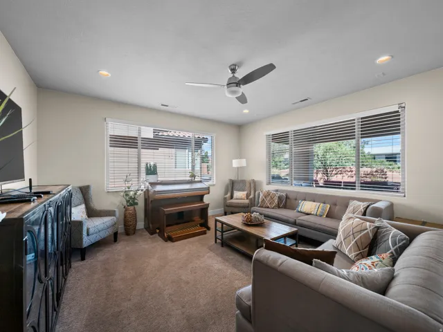 Recessed lighting, ceiling fan, and large windows with horizontal blinds