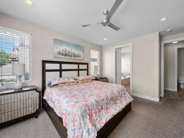 Textured accent wall, recessed lighting, ceiling fan, carpet flooring, window with blinds