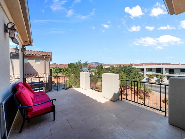 Outdoor balcony featuring a tiled surface and black metal railing