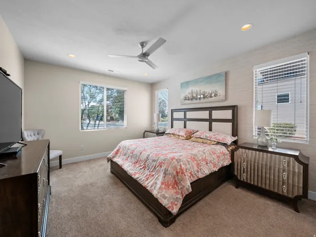 Carpeted room with recessed lighting, a ceiling fan, and multiple windows