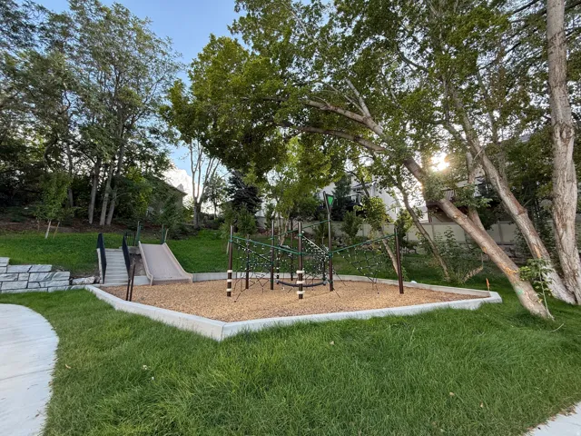Integrated play area featuring a slide, climbing structure, and wood chip ground cover