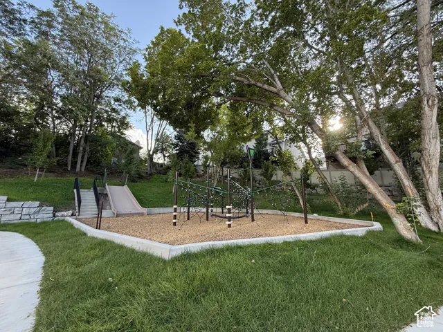 Integrated play area featuring a slide, climbing structure, and wood chip ground cover