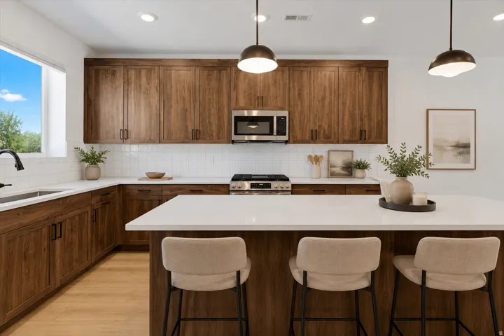 Kitchen featuring wood-finish cabinetry, white subway tile backsplash, white countertops, and stainless steel appliances