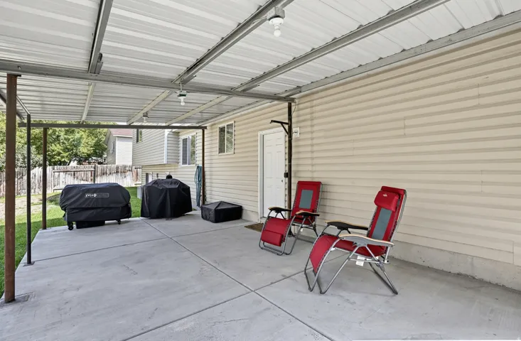 Covered patio featuring a concrete slab and overhead lighting
