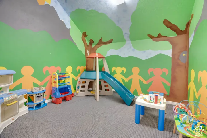 Interior room featuring neutral-toned carpeting and decorative mural-painted walls