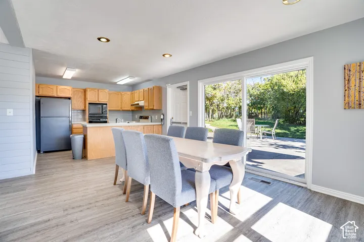 Kitchen featuring light-finish cabinetry, recessed ceiling lighting, and wood-finish flooring, with a sliding glass door providing external access