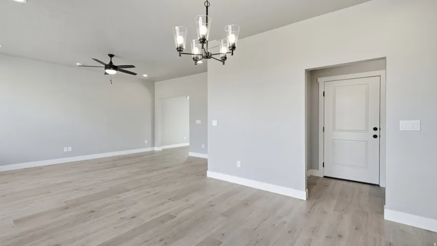 Wood-finish flooring throughout, recessed lighting, ceiling fan fixture, and a contemporary chandelier